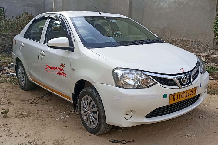 Rajasthan Visits white sedan taxi for your Rajasthan journey